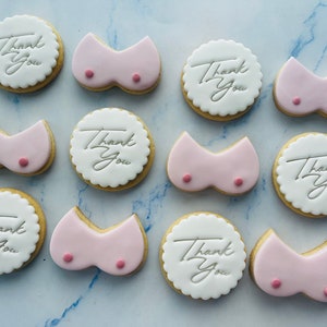 May include: Assortment of decorated cookies with pink icing and the text "Thank You" in white icing.