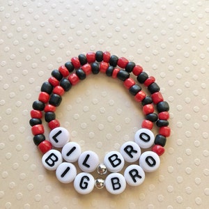 May include: Red and black beaded bracelet with white beads spelling out "Big Bro" and "Lil Bro".