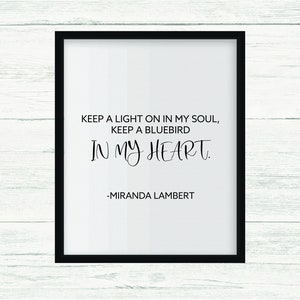 May include: Black and white printable wall art featuring a quote by Miranda Lambert: "Keep a light on in my soul, keep a bluebird in my heart."