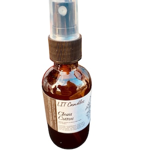 May include: A brown glass bottle with a clear spray nozzle and a white label that reads "LIT Candles Clean Cotton Smoke Odor Eliminating Mist".