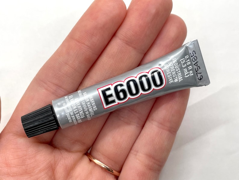 May include: A silver tube of E6000 industrial strength adhesive with a black cap. The tube is labeled with the product name, size, and warnings.