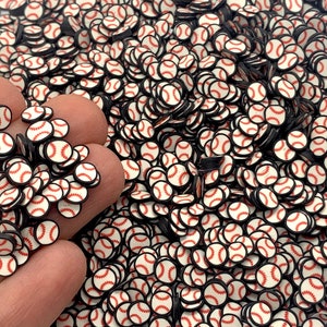 May include: A large quantity of white and red baseball-themed confetti. The confetti is in the shape of baseballs with black outlines and red stitching.