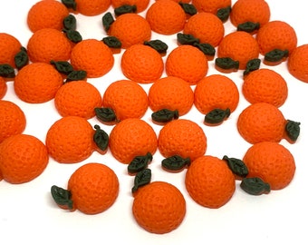May include: A collection of 30 orange-colored, round, textured, resin orange fruit cabochons with green leaves.