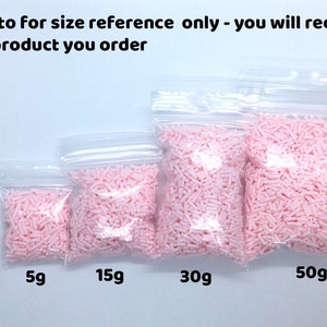 May include: Four clear plastic bags filled with pink sprinkles. The bags are labeled with the weights 5g, 15g, 30g, and 50g.