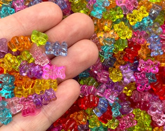 May include: A large assortment of colorful gummy bear shaped plastic beads. The beads are translucent and come in a variety of colors, including red, orange, yellow, green, blue, purple, and pink.