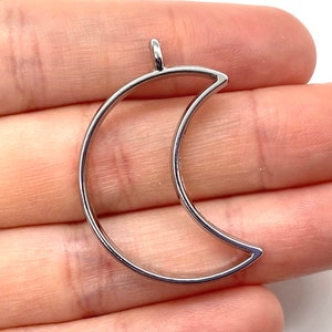 May include: Silver-toned metal crescent moon charm with a loop at the top for attaching to jewelry or other crafts.