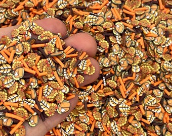 May include: A mix of polymer clay pieces in various shapes and colors. The pieces include cartoon turkeys, leaves, and orange sticks. The color palette is primarily orange, brown, and yellow, creating a fall or Thanksgiving theme.