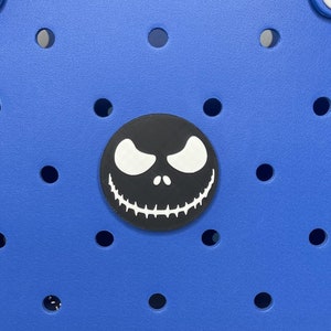 May include: A blue tote bag with a black and white Jack Skellington face patch. The bag has a white logo that says "BOGO" on the bottom.