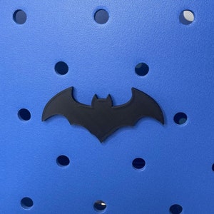 May include: A blue tote bag with a black bat logo and the word "bogg" on the bottom.