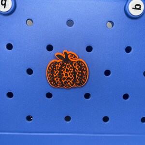 May include: A blue plastic storage bin with a black and orange pumpkin sticker. The pumpkin has a leopard print design.
