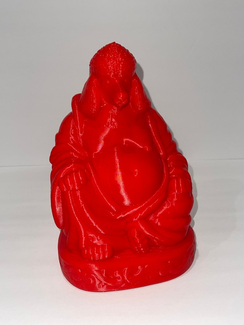 May include: A vibrant red Buddha statue, featuring a seated figure with a large belly and serene expression. The statue is detailed with folds in the robes and a textured head. The base has an ornate design.