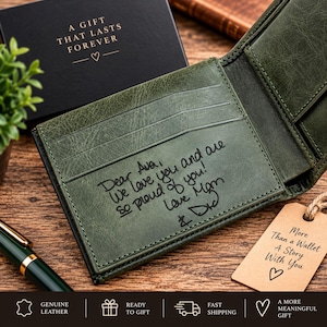 Könnte beinhalten: Ein dunkelgrünes Leder-Bifold-Portemonnaie mit einer Innengravur, die lautet: Dear Ava, We love you and are so proud of you! Love Mom & Dad. Das Portemonnaie verfügt über mehrere Kartenfächer und ein beiges Papieretikett mit der Aufschrift: More than a Wallet A Story With You.