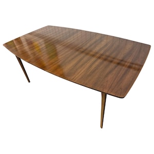May include: A rectangular wooden dining table with a rich brown finish. The table has a smooth, glossy surface and four tapered legs. The table is approximately 60 inches long and 36 inches wide.