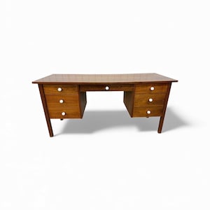 May include: A mid-century modern wooden desk with a rectangular top and six drawers. The desk has a warm brown finish, white drawer pulls, and angled legs. The desk is approximately 60 inches wide.