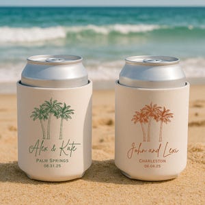May include: Two white can coolers with palm tree designs. The cooler on the left has green palm trees and the text 'Alex & Kate', 'Palm Springs', and '08.31.25'. The cooler on the right has orange palm trees and the text 'John and Lexi', 'Charleston', and '06.04.25'.