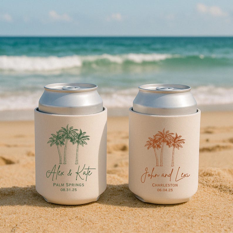May include: Two white can coolers with palm tree designs. The cooler on the left has green palm trees and the text 'Alex & Kate', 'Palm Springs', and '08.31.25'. The cooler on the right has orange palm trees and the text 'John and Lexi', 'Charleston', and '06.04.25'.