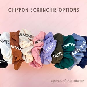 May include: A collection of chiffon scrunchies in black, white, sienna, almond, rose, lilac, olive, hunter, dusty blue, and navy. The text reads CHIFFON SCRUNCHIE OPTIONS and approx. 5" in diameter. Each scrunchie has a gathered, ruffled fabric texture.