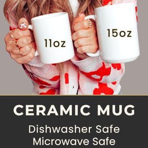 May include: Two white ceramic mugs, one labeled "11oz" and the other "15oz", are held up. The mugs are displayed against a background of a red and white patterned sweater. The image also includes the text "CERAMIC MUG", "Dishwasher Safe", "Microwave Safe", and "BPA free".