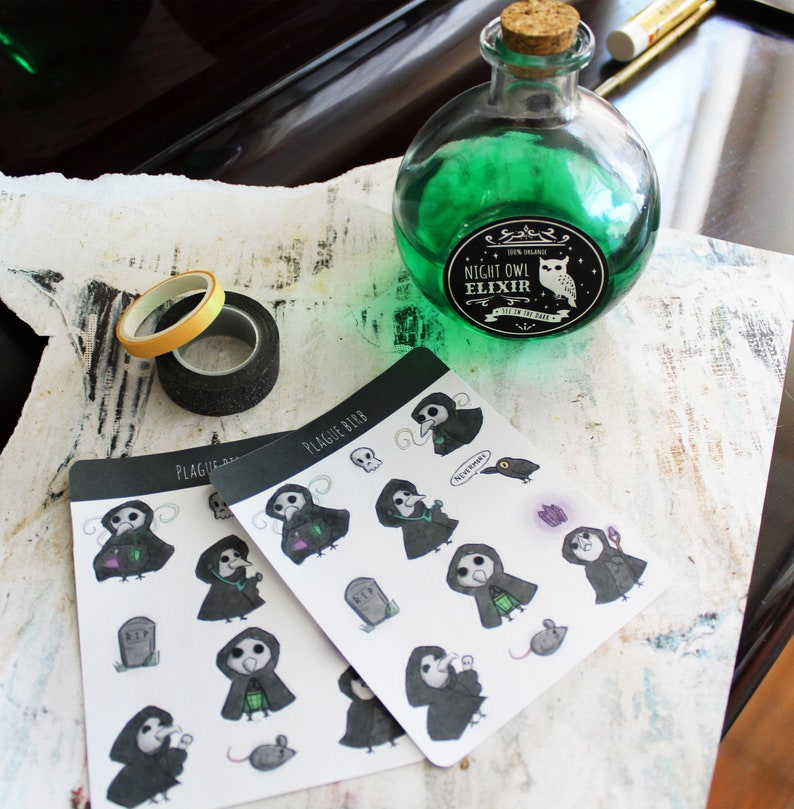 May include: Two sheets of stickers featuring a plague doctor character with a black and white design. The stickers are on a white background and have the text "Plague Bird" on them. A green glass bottle with a label that reads "Night Owl Elixir" is in the background.