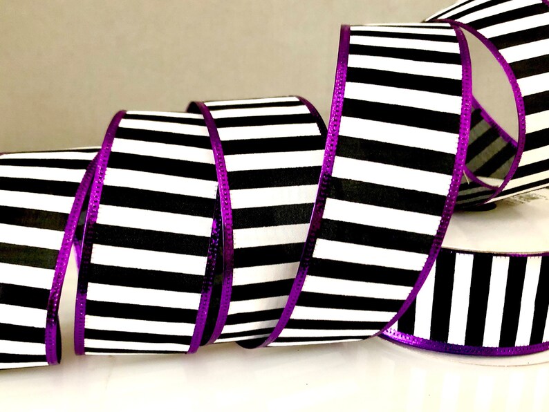 May include: Black and white striped ribbon with a purple metallic edge. The ribbon is 2.5 inches wide.