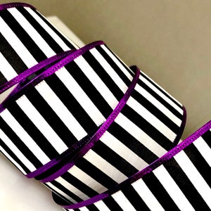 May include: Black and white striped ribbon with a purple metallic edge. The ribbon is 2.5 inches wide.