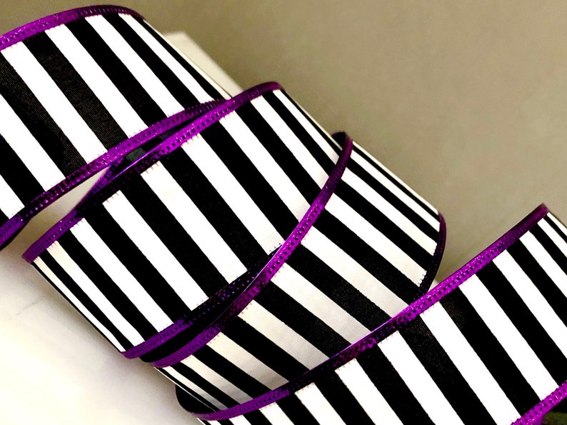 May include: Black and white striped ribbon with a purple metallic edge. The ribbon is 2.5 inches wide.