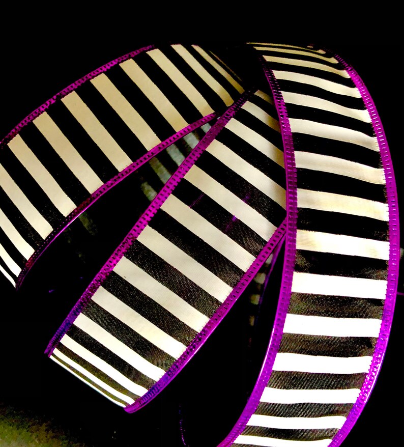 May include: Black and white striped ribbon with a purple edge. The ribbon is curled and folded, showing the pattern.