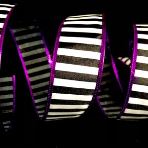May include: Black and white striped ribbon with a purple edge. The ribbon is curled and twisted.