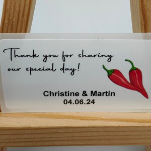 Op de afbeelding: Witte bedankkaart met rode pepers en de tekst "Bedankt voor het delen van onze speciale dag! Christine & Martin 04.06.24"