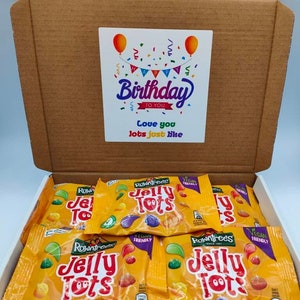 May include: A cardboard box filled with small bags of Rowntrees Jelly Tots sweets. The box has a birthday card on top with the text "Happy Birthday to You Love you lots just like".