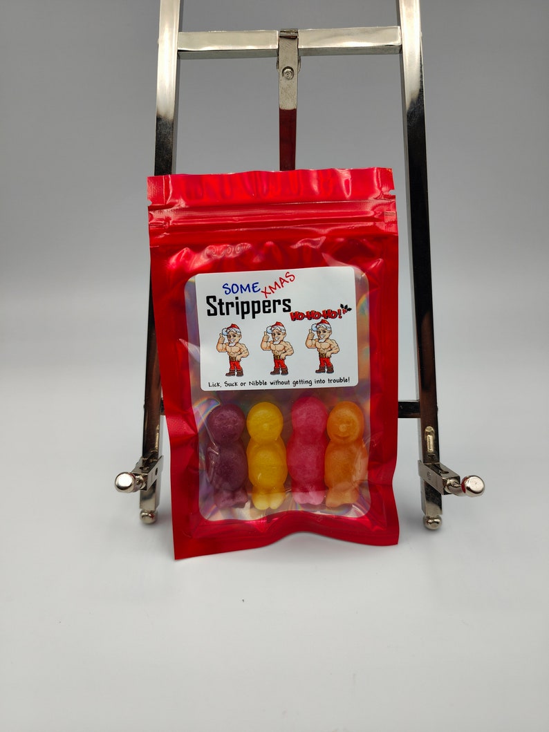 K&ouml;nnte beinhalten: Ein wiederverschlie&szlig;barer Beutel aus rotem Material mit einem Sichtfenster, in dem drei bunte Gummib&auml;rchen in Menschenform zu sehen sind. Der Beutel hat ein wei&szlig;es Etikett mit dem Text "Some Xmas Strippers Ho-ho-ho! Lick, Suck or nibble without getting into trouble!"