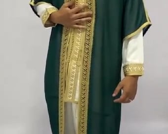 Könnte beinhalten: Eine lange, grüne Robe mit goldener Stickerei. Die Robe hat einen hohen Kragen und lange Ärmel. Die Robe wird über einer weißen Hose getragen.