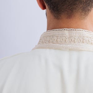 May include: A white shirt with a decorative embroidered collar.
