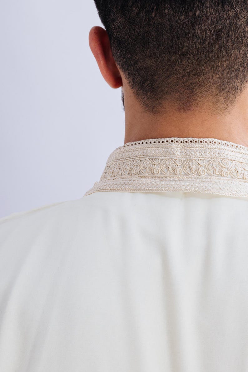 May include: A white shirt with a decorative embroidered collar.