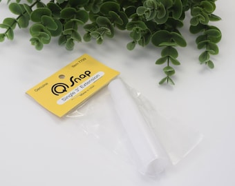 Könnte beinhalten: Ein weißes 7,62 cm langes Kunststoff-Verlängerungsstück für einen Q-Snap-Rahmen, verpackt in einem Klarsichtbeutel mit gelber Kopfkarte. Die Karte trägt den Text Genuine, Q-Snap, Item 7799, Single 3 inch Extension und Made in USA.