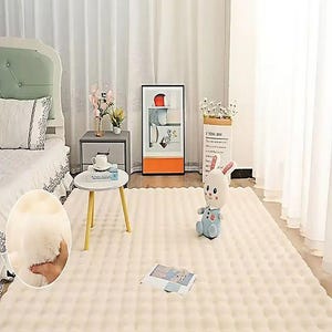 Puede incluir: Una alfombra de área texturizada de color crema con un diseño afelpado y con mechones. La alfombra está en un dormitorio, con una cama, una mesita de noche y objetos decorativos. Un juguete de peluche de conejito está sobre la alfombra.