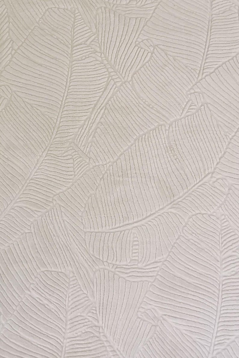 May include: White textured wallpaper with a repeating pattern of embossed banana leaves.