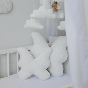 Puede incluir: Cuna blanca con s&aacute;bana bajera blanca y tres almohadas blancas y esponjosas en forma de nube. Un dosel blanco cuelga sobre la cuna.