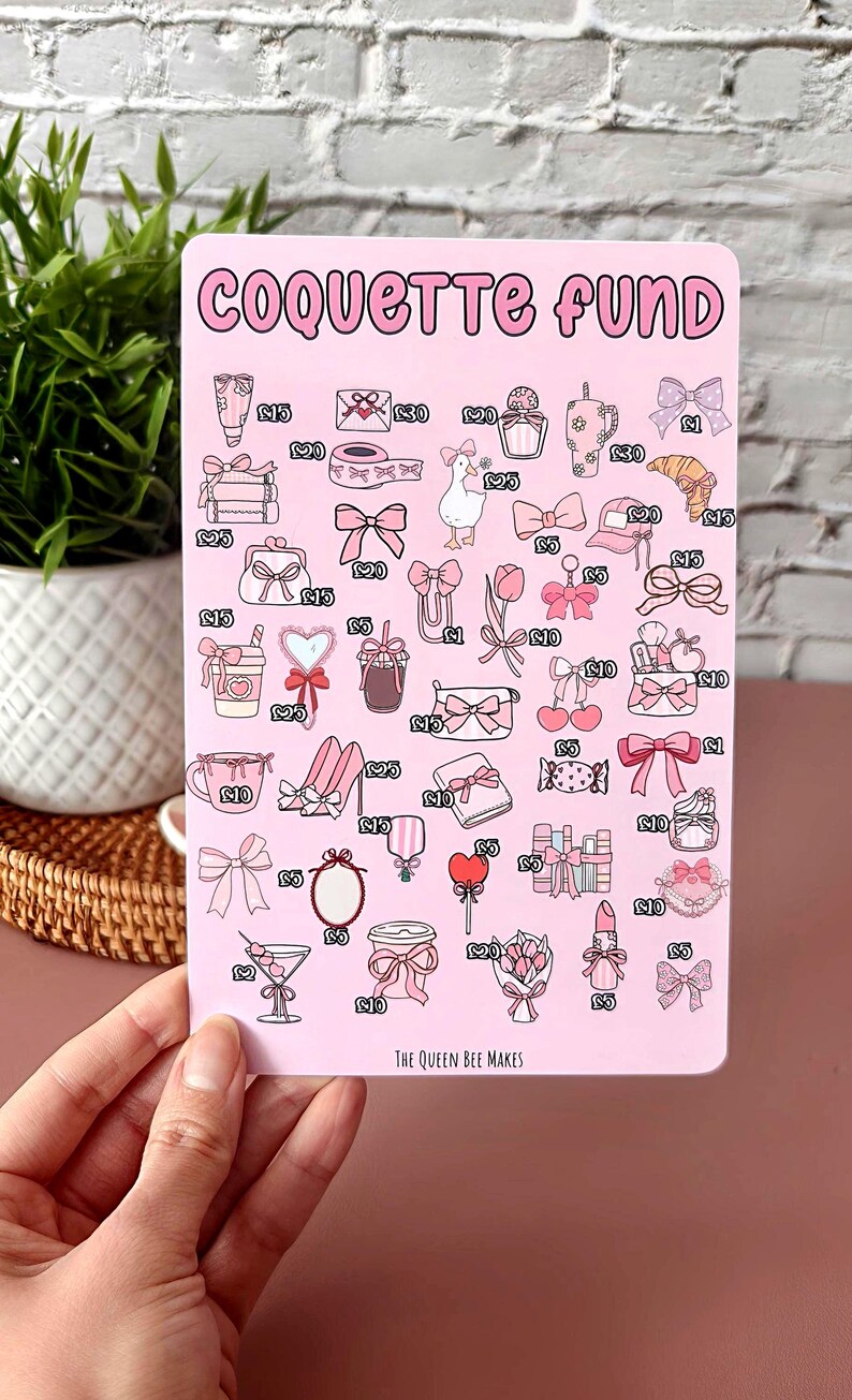 May include: A pink sticker with the words "COQUETTE FUND" in a bubble font. The sticker features illustrations of bows, shoes, and other feminine items. The text "THE QUEEN BEE MAKES" is at the bottom.