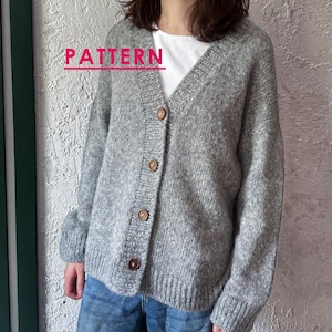 Könnte beinhalten: Grauer Cardigan mit V-Ausschnitt und Holzknöpfen. Der Pullover wird über einem weißen T-Shirt und einer blauen Jeans getragen. Das Wort "PATTERN" ist in Rosa oben im Bild geschrieben.