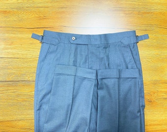May include: A pair of gray dress pants with a single button closure and belt loops. The pants have a crease down the front of each leg.