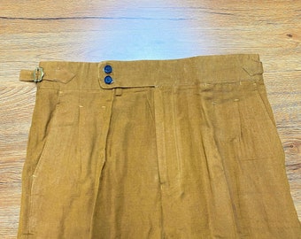 May include: A pair of brown pleated trousers with a belt loop and two buttons at the waist.
