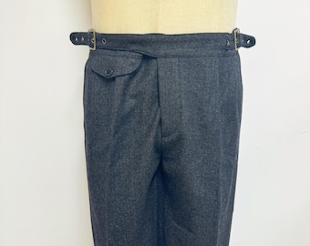 May include: Gray wool pants with a single button closure and a belt with two buckles.
