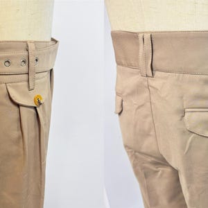 Puede incluir: Pantal&oacute;n beige de cintura alta con cintur&oacute;n. El pantal&oacute;n tiene un frente plisado y un solo bolsillo trasero con cierre de bot&oacute;n.