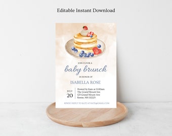 May include: A light blue and white baby shower invitation with a watercolor illustration of a stack of pancakes topped with whipped cream, strawberries, and blueberries. The text reads "Join us for a baby brunch in honor of Isabella Rose" and includes the date, time, location, and RSVP information.