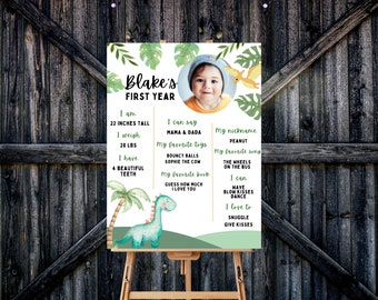 Puede incluir: Un póster ilustrado verde y marrón con una foto de un bebé varón con un gorro blanco. El póster dice "Blake's First Year" y enumera detalles sobre el primer año del bebé, incluyendo su altura, peso, juguetes favoritos y canciones.