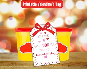 Può includere: Un'etichetta stampabile per San Valentino con coriandoli rosa e dorati e un fiocco rosso. L'etichetta dice "You are a Won-Doh-Ful Friend! Happy Valentine's Day!"