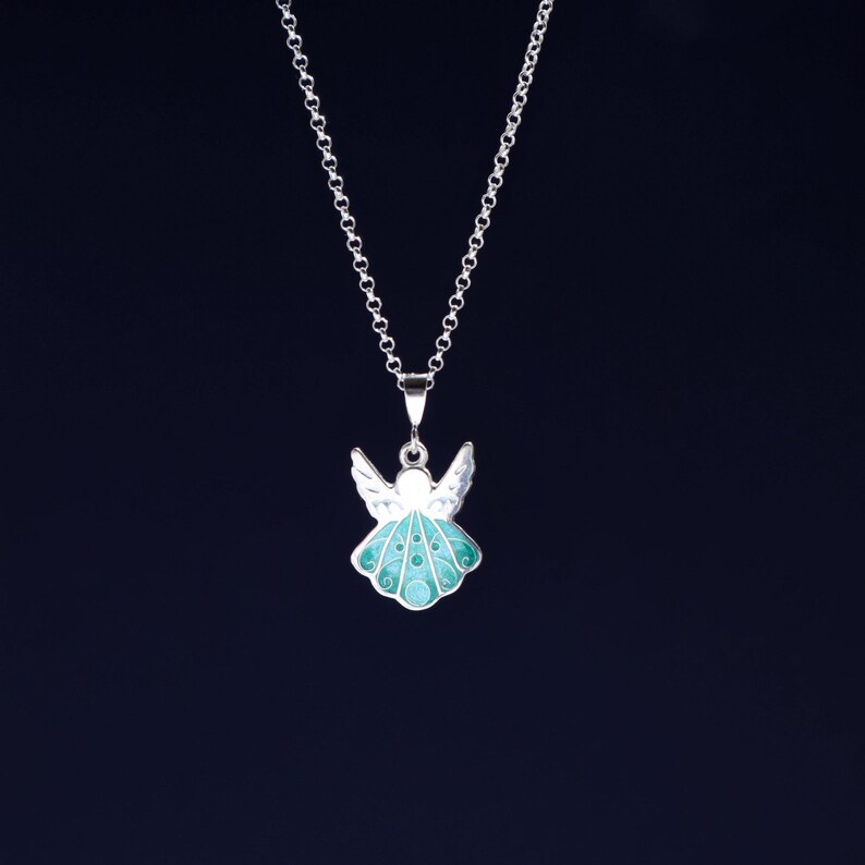 Op de afbeelding: Een zilveren ketting met een teal en witte emaille engel hanger.