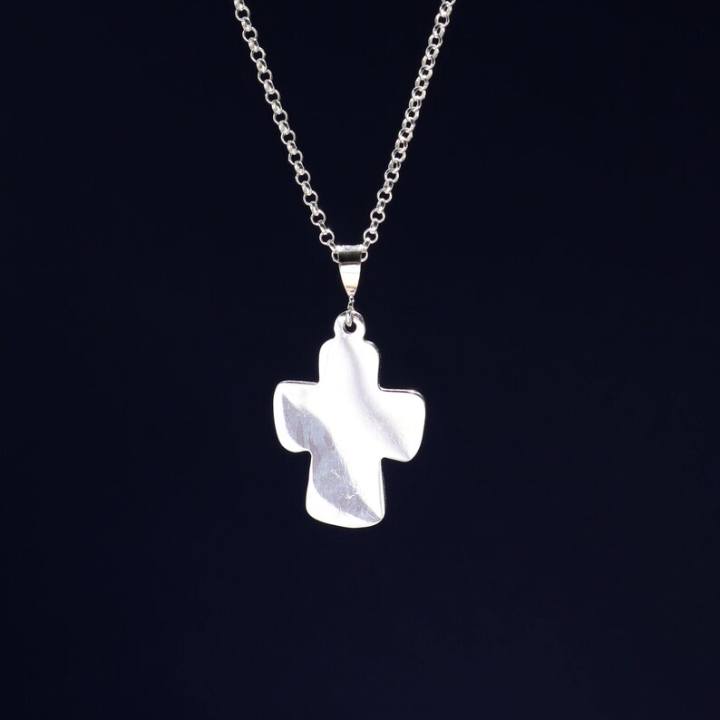 May include: A silver chain necklace with a plain silver cross pendant.