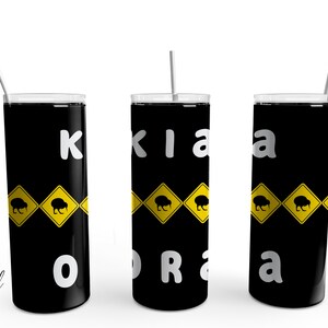 May include: Three black stainless steel tumblers with a white background. Each tumbler has a yellow and black road sign with a kiwi bird on it. The tumblers are labeled "Kiwiana" with each letter on a separate tumbler.